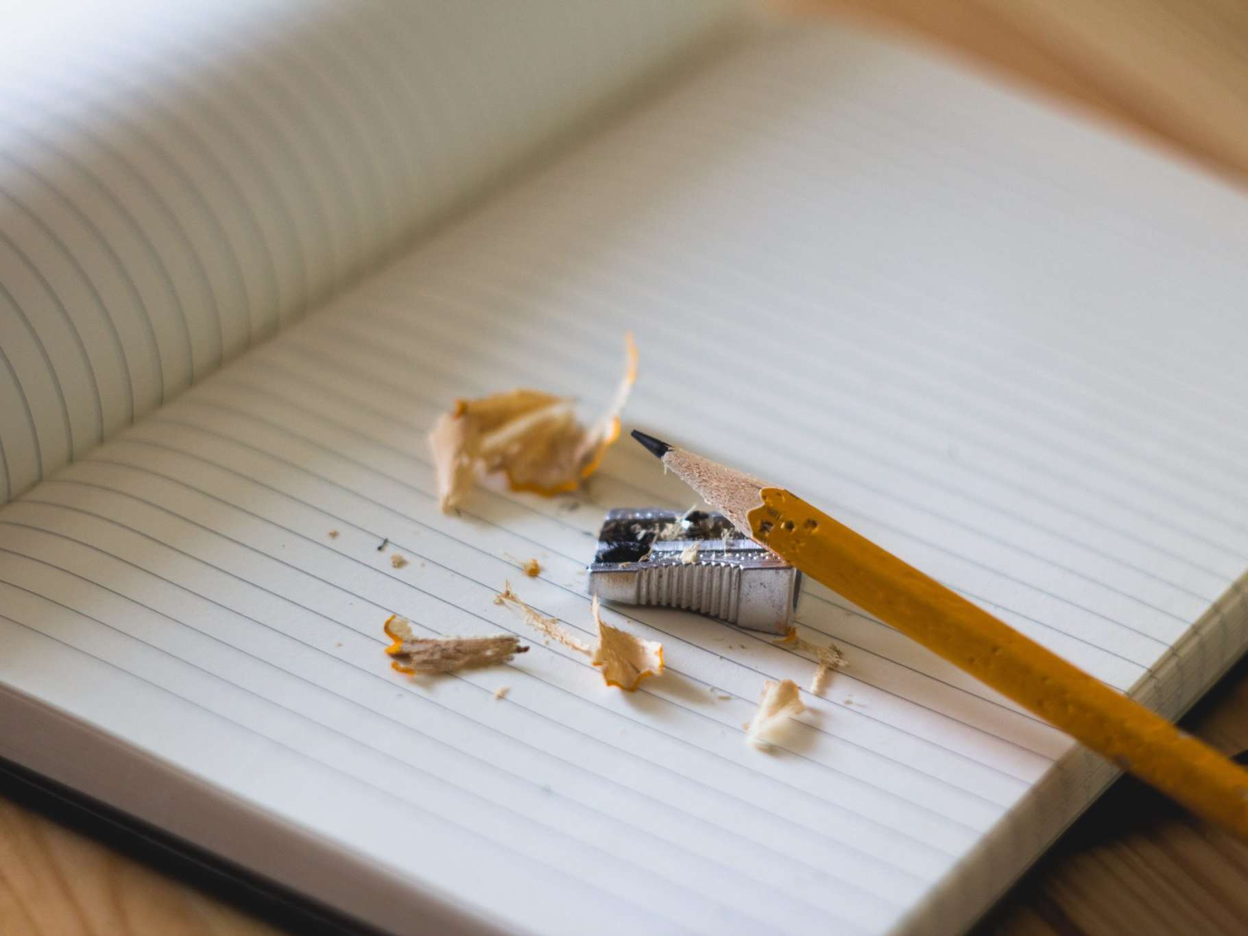 An image of a notebook with pencil shavings on top of it