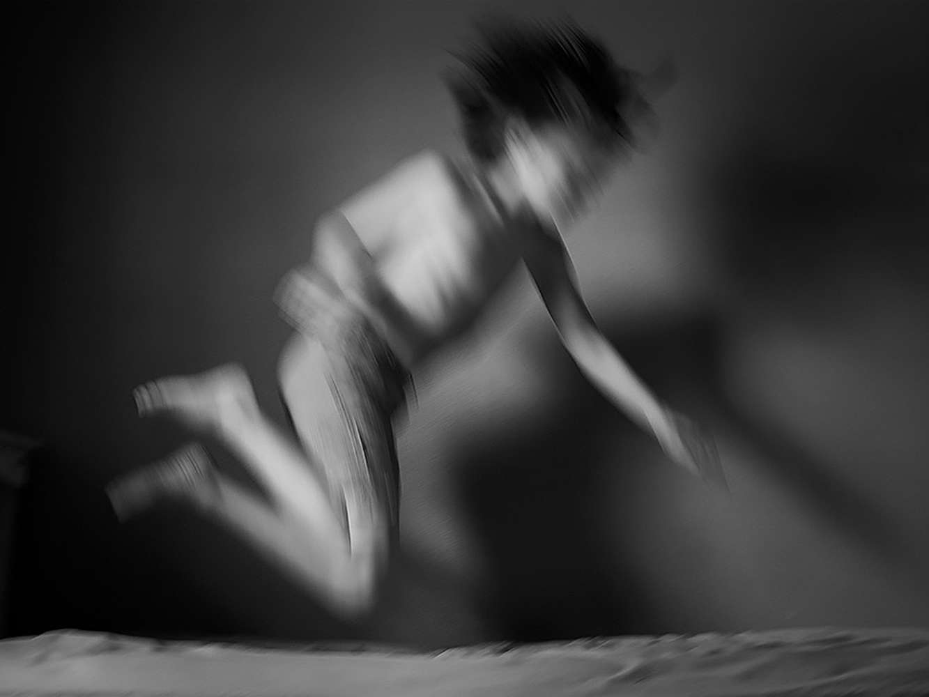 Child leaping on a bed
