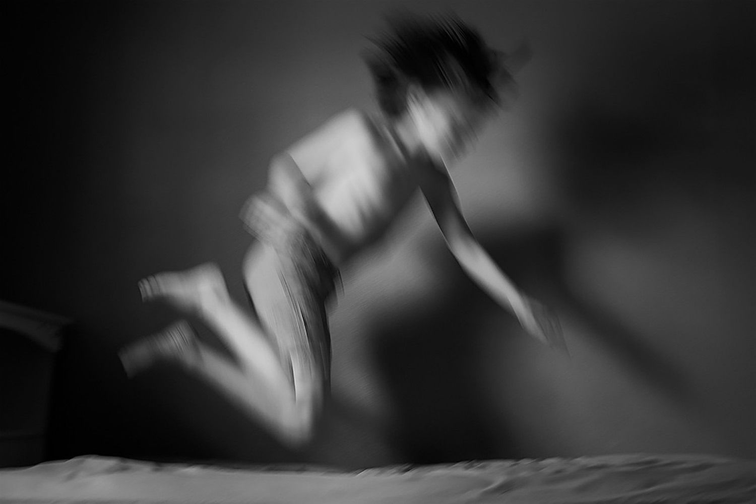 Child leaping on a bed