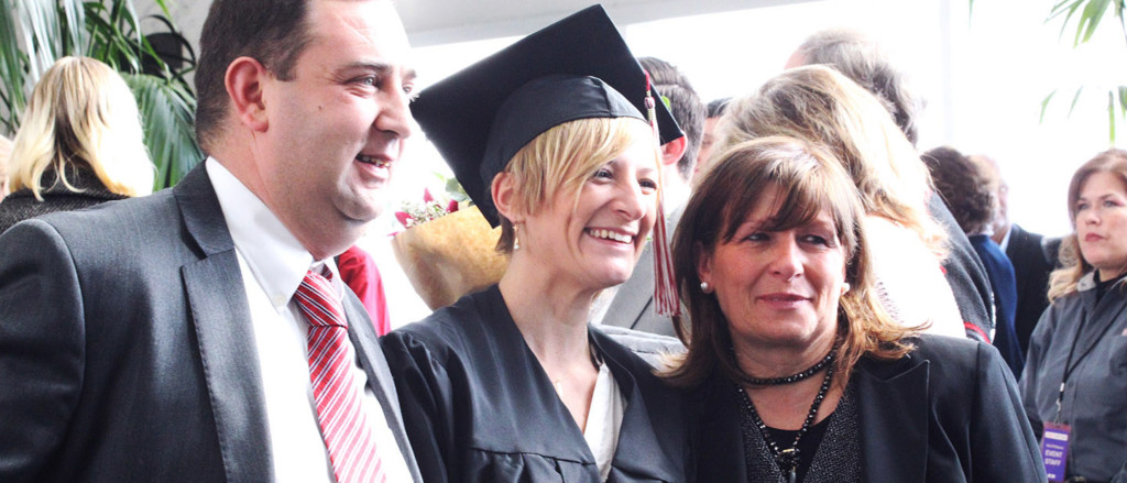 student with parents on graduation day