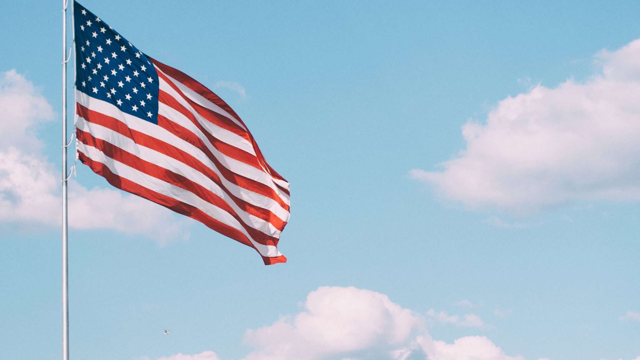 a U.S. flag set against a blue sky to celebrate Veterans Day