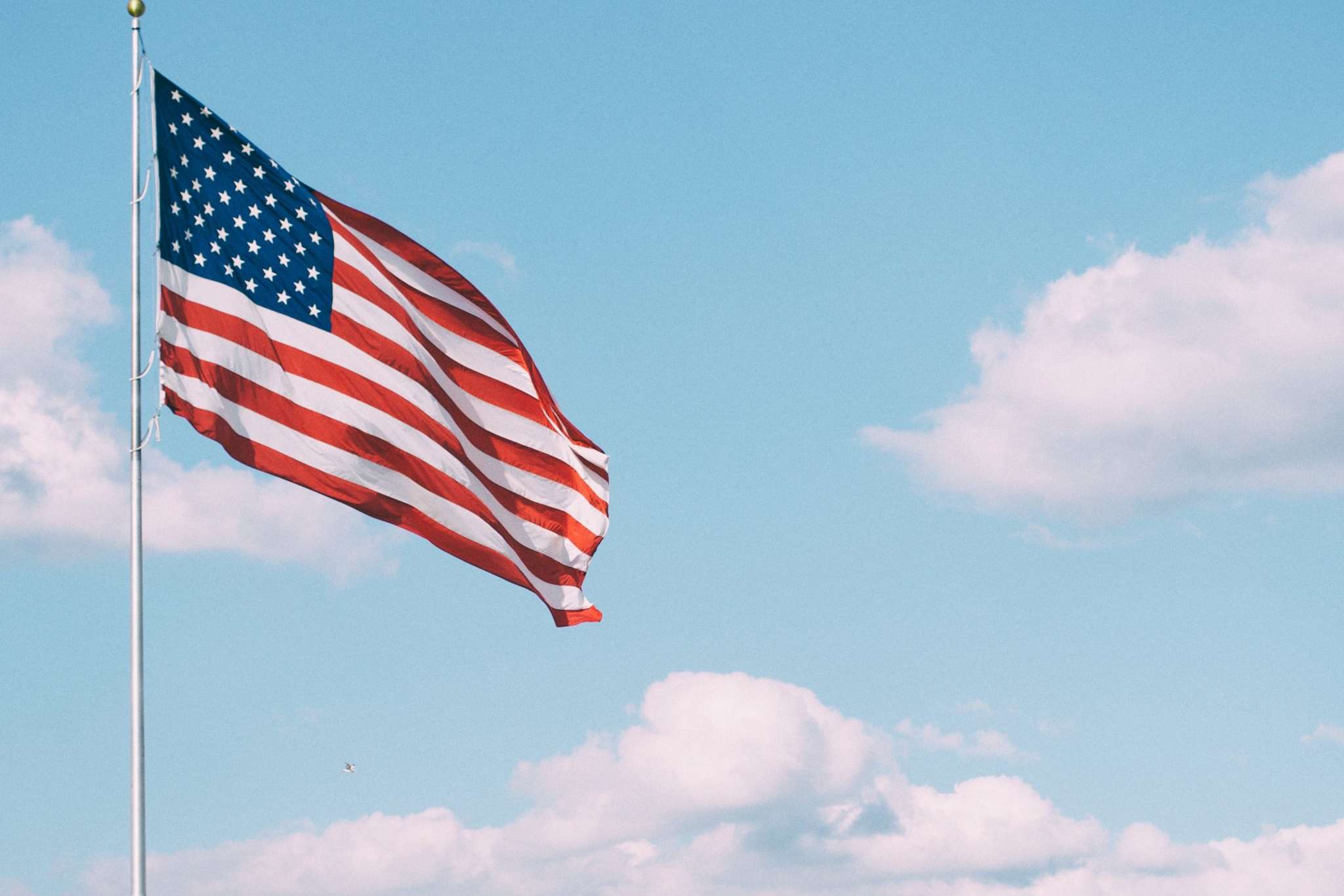 a U.S. flag set against a blue sky to celebrate Veterans Day
