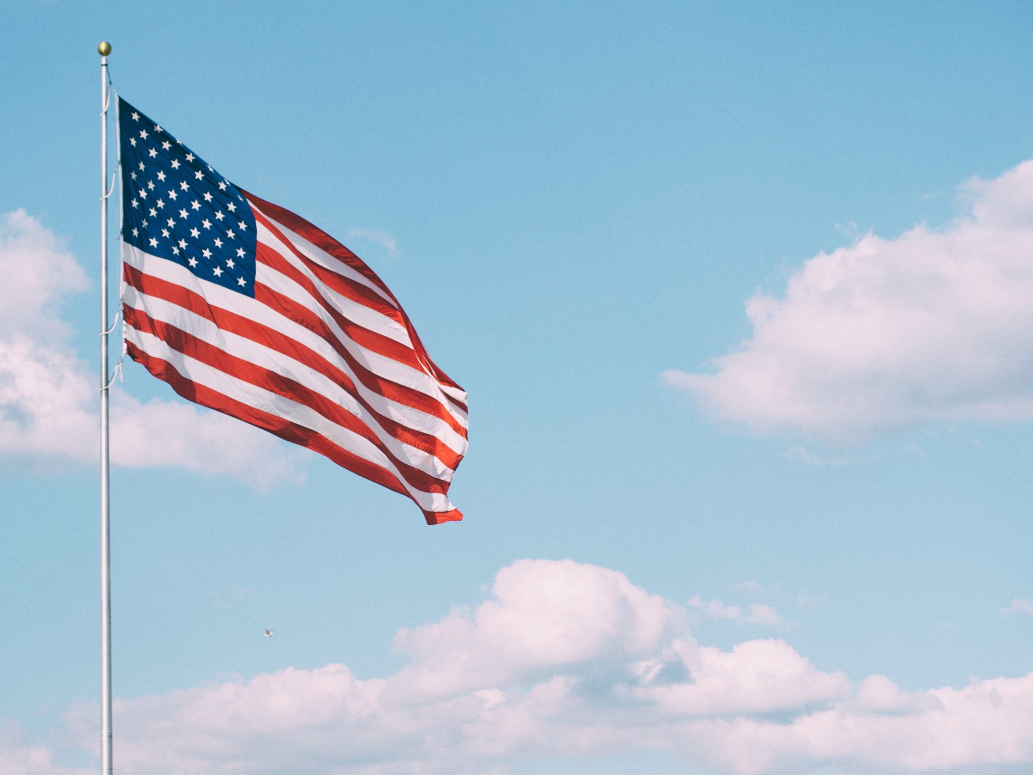 a U.S. flag set against a blue sky to celebrate Veterans Day