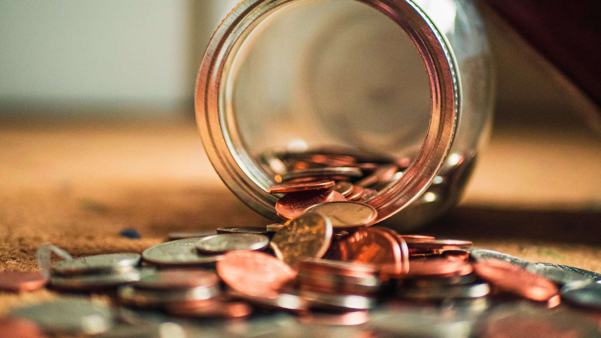 glass jar with coins lying on its side