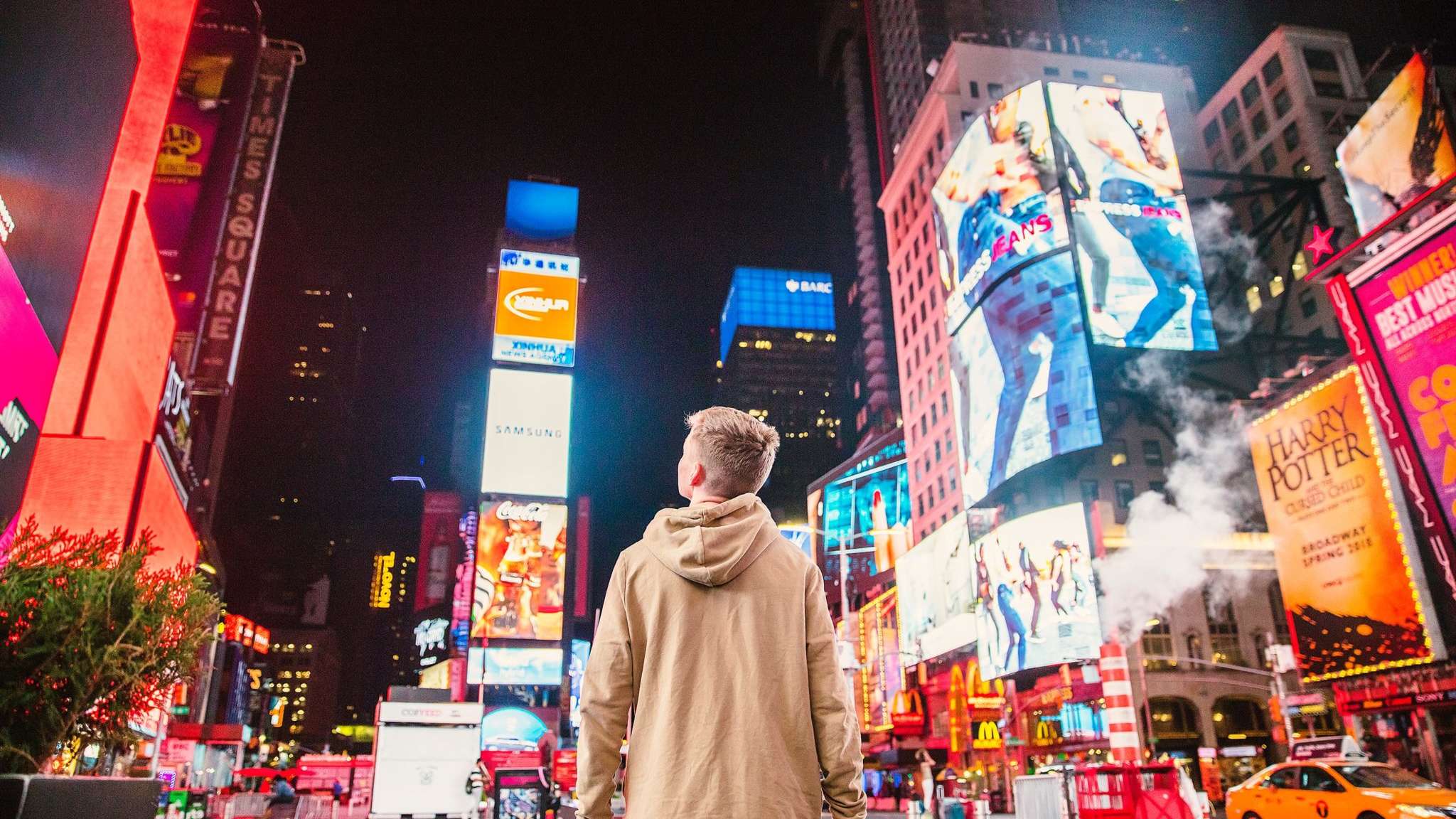 person looking at illuminated billboard advertisements