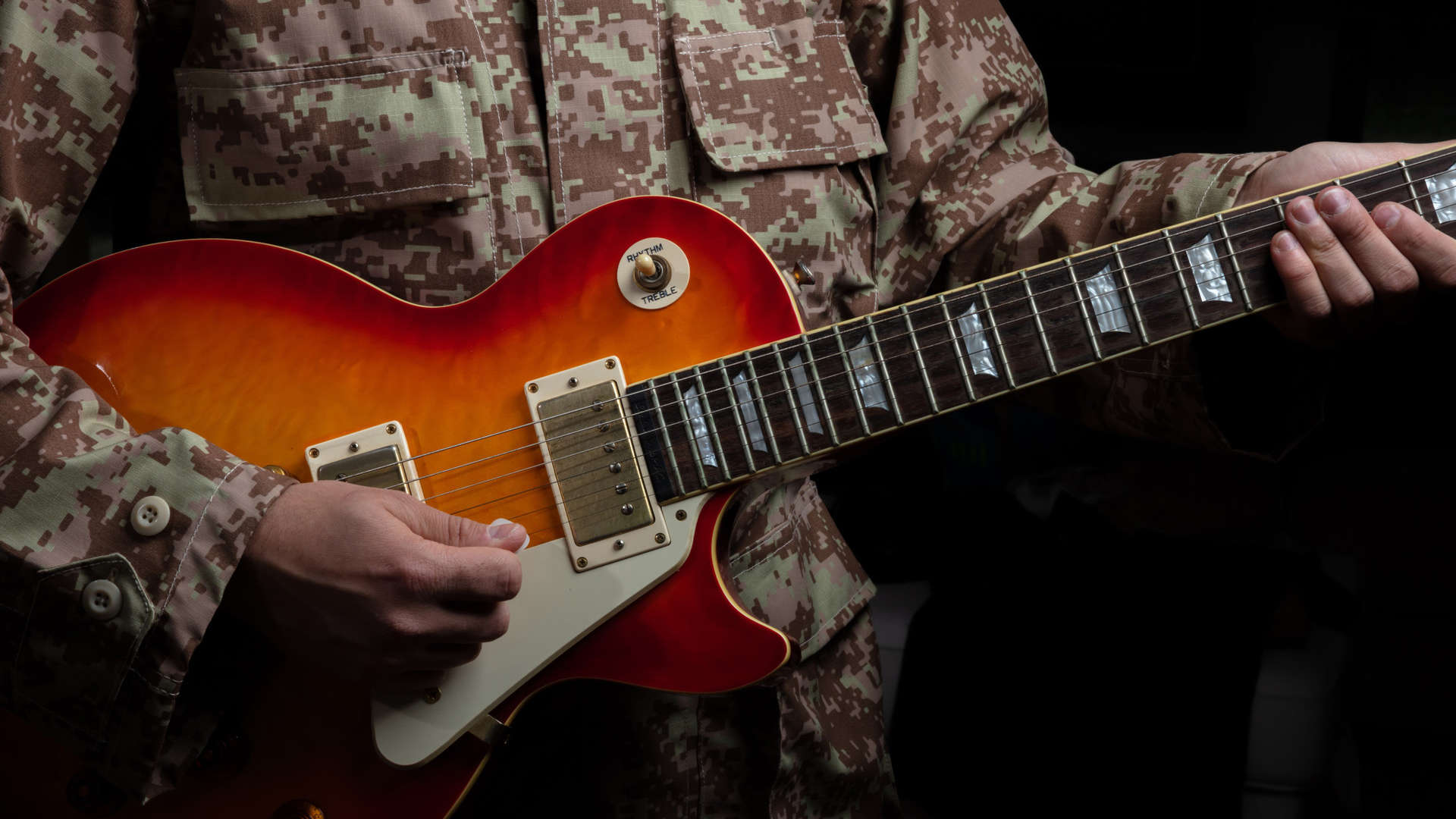 Soldier in uniform playing guitar