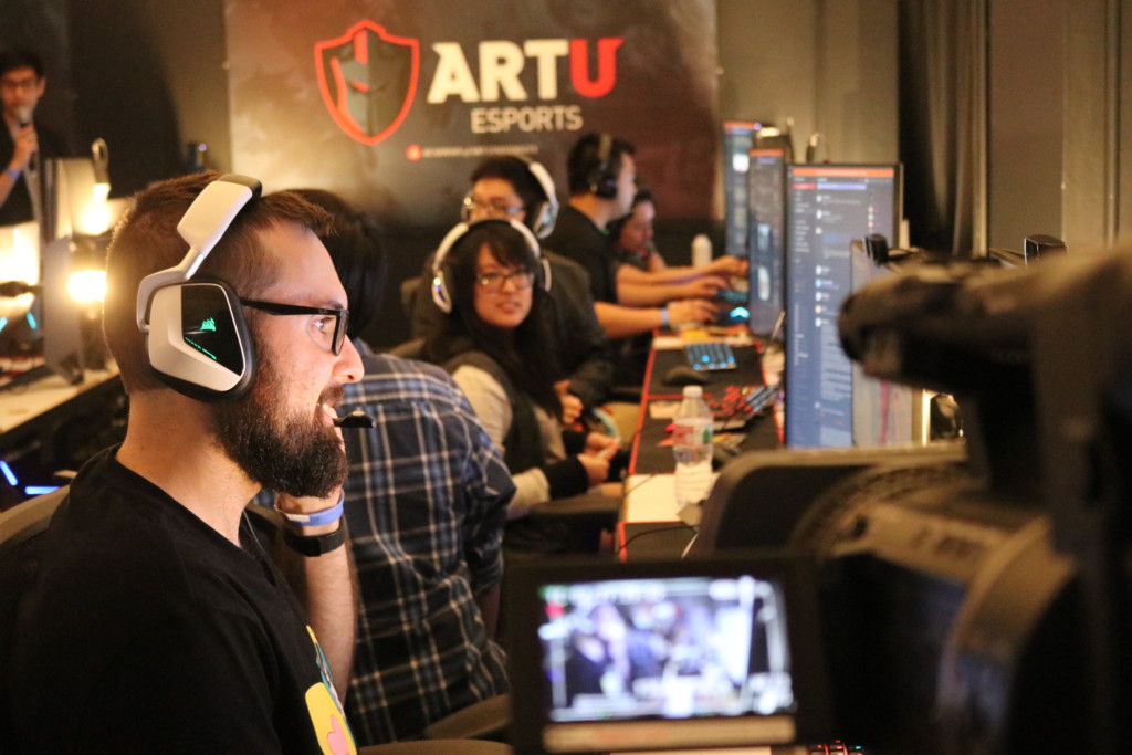 Game developer working on his computer in a busy room