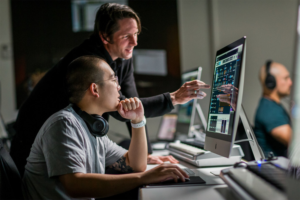 2 men collaborating in front of a computer